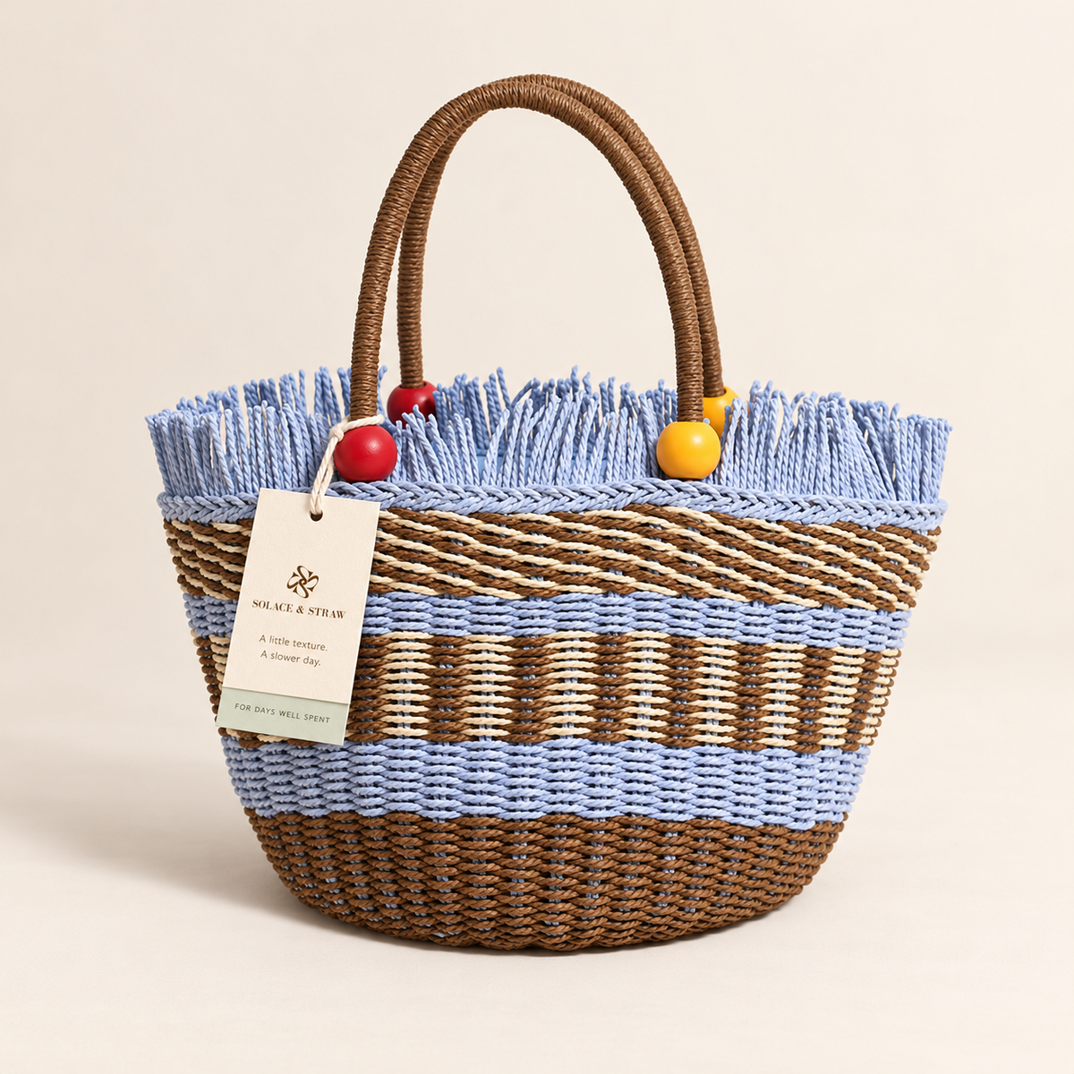 Wooden Bead Bucket Bag with pale blue woven accents and beaded handles, front view with a Solace & Straw hangtag