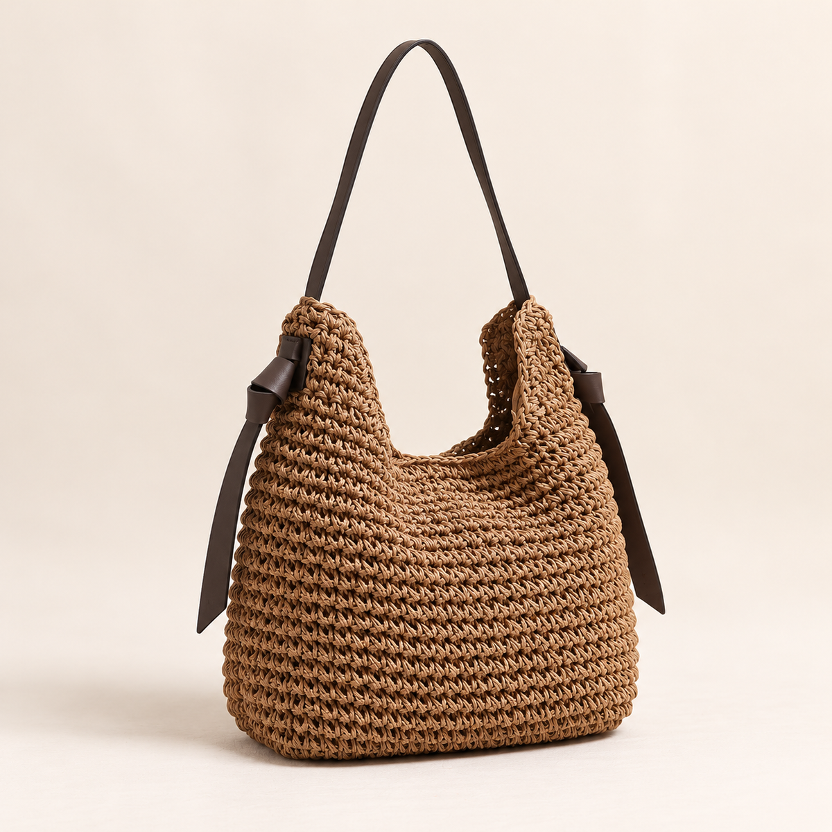 Tassel Cylinder Bag, angled view showing a dark shoulder strap and long side ties