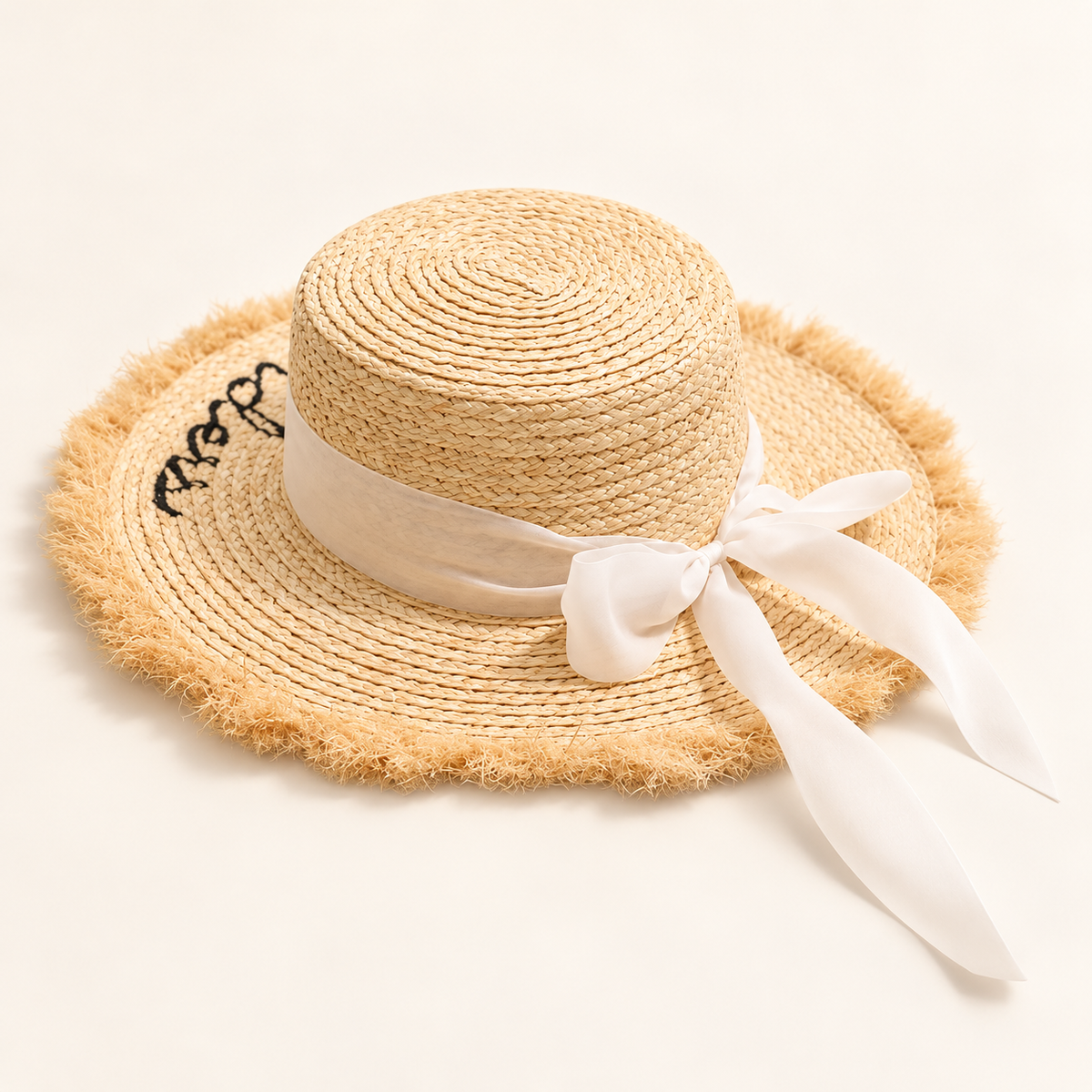 Ribbon Straw Sun Hat, angled view showing an ivory bow and frayed brim