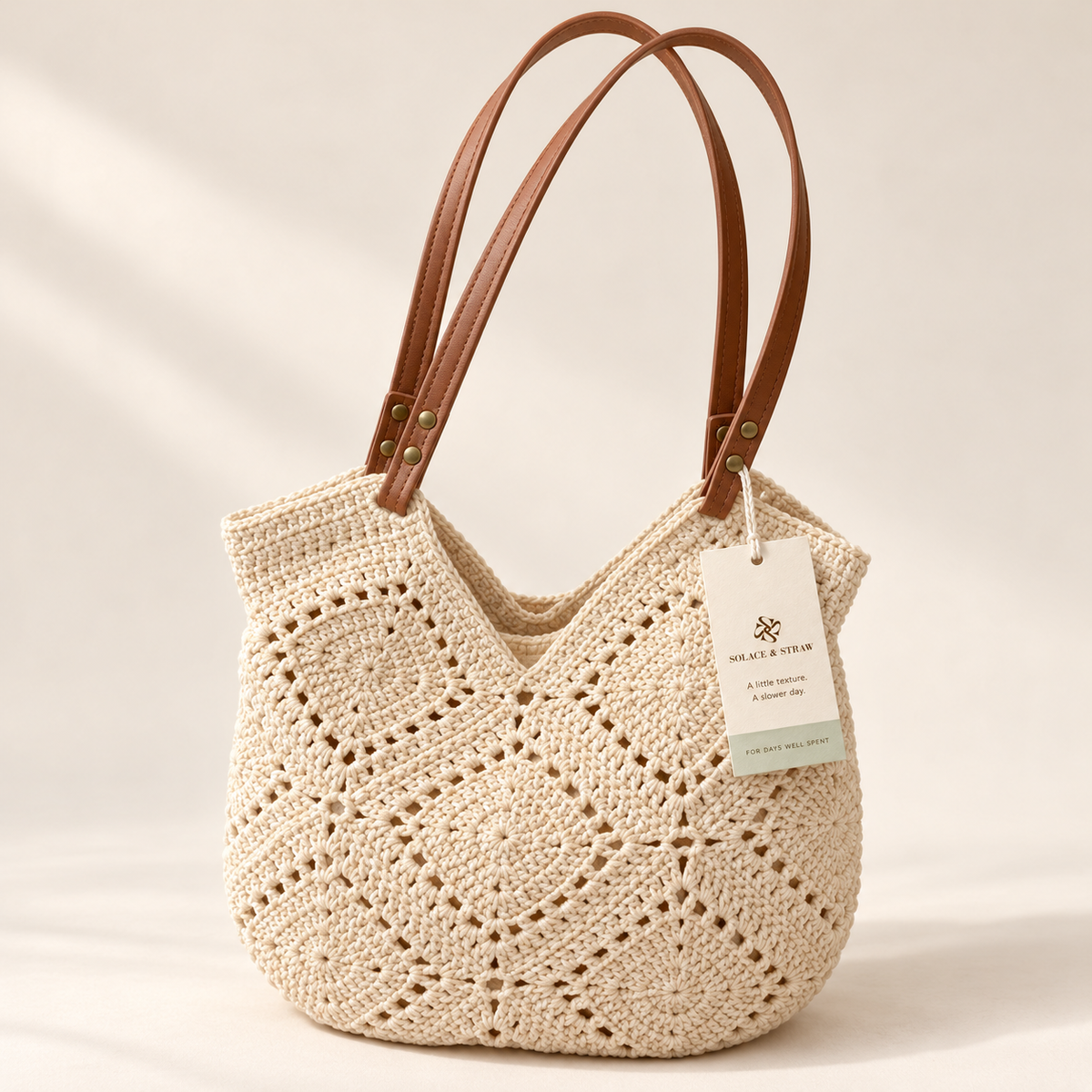 Crochet Patchwork Shoulder Bag in ivory / no charm, front view with Solace & Straw hangtag