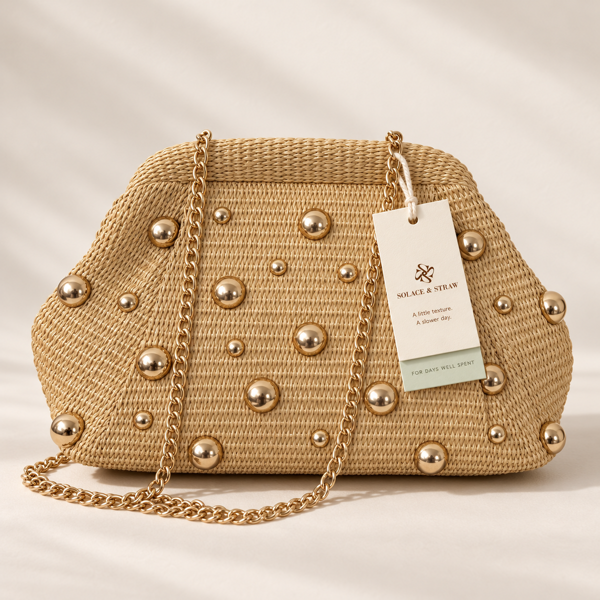 Gold Stud Woven Clutch in natural / gold studs, front view with Solace & Straw hangtag