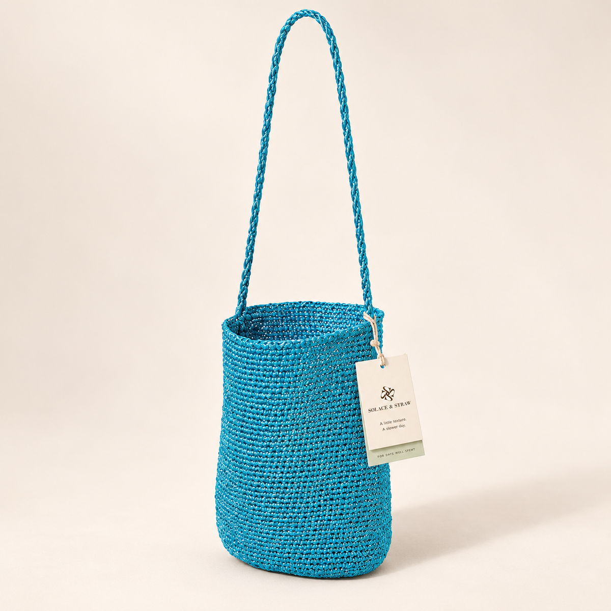 Braided Strap Woven Bucket Bag — Turquoise, turquoise, front view with Solace & Straw hangtag