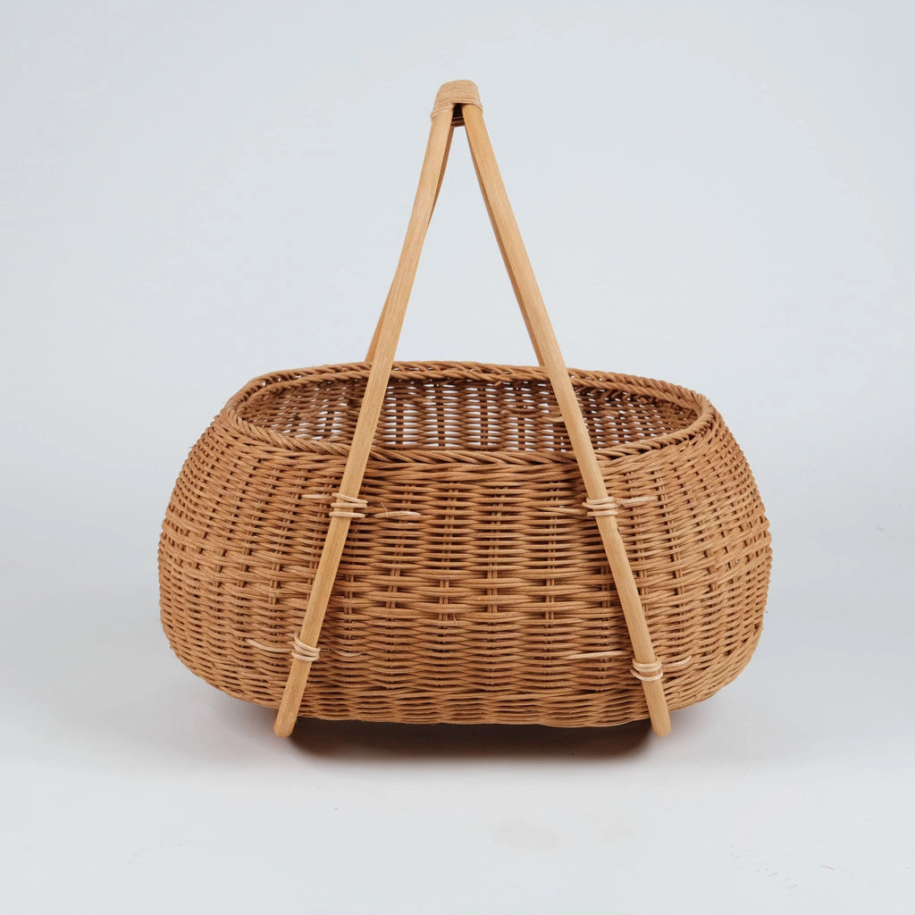 Nordic rattan picnic basket with A-frame wooden handles, 
natural honey tone, handwoven wicker, front view