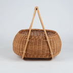 Nordic rattan picnic basket with A-frame wooden handles, 
natural honey tone, handwoven wicker, front view