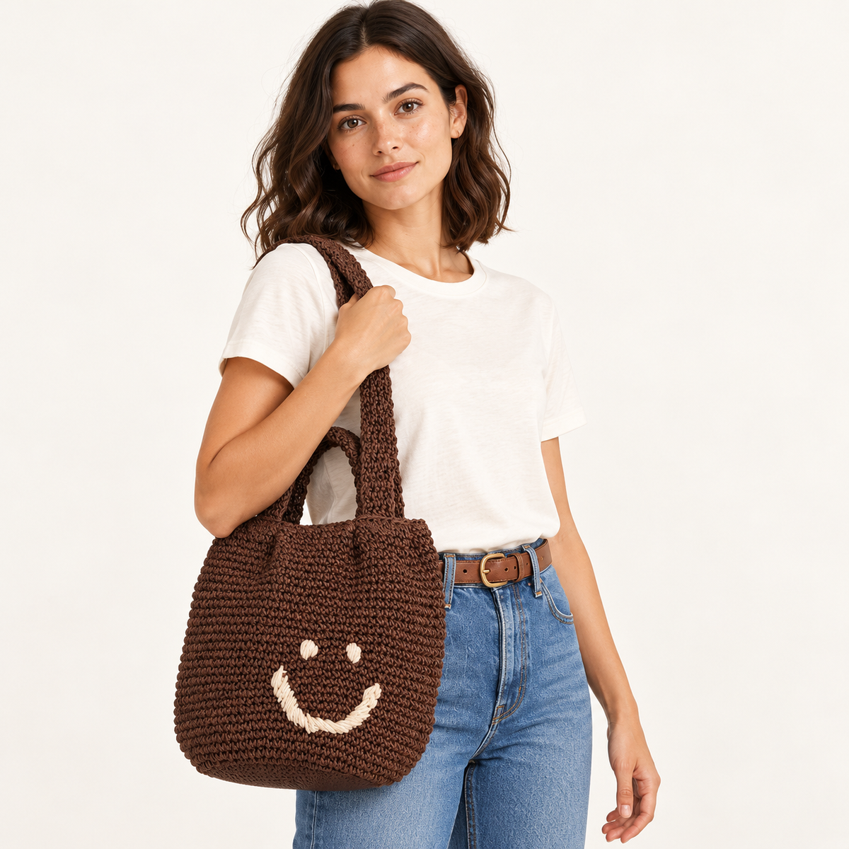 Woman carrying the Smiley Woven Shoulder Bag with a stitched smiley face
