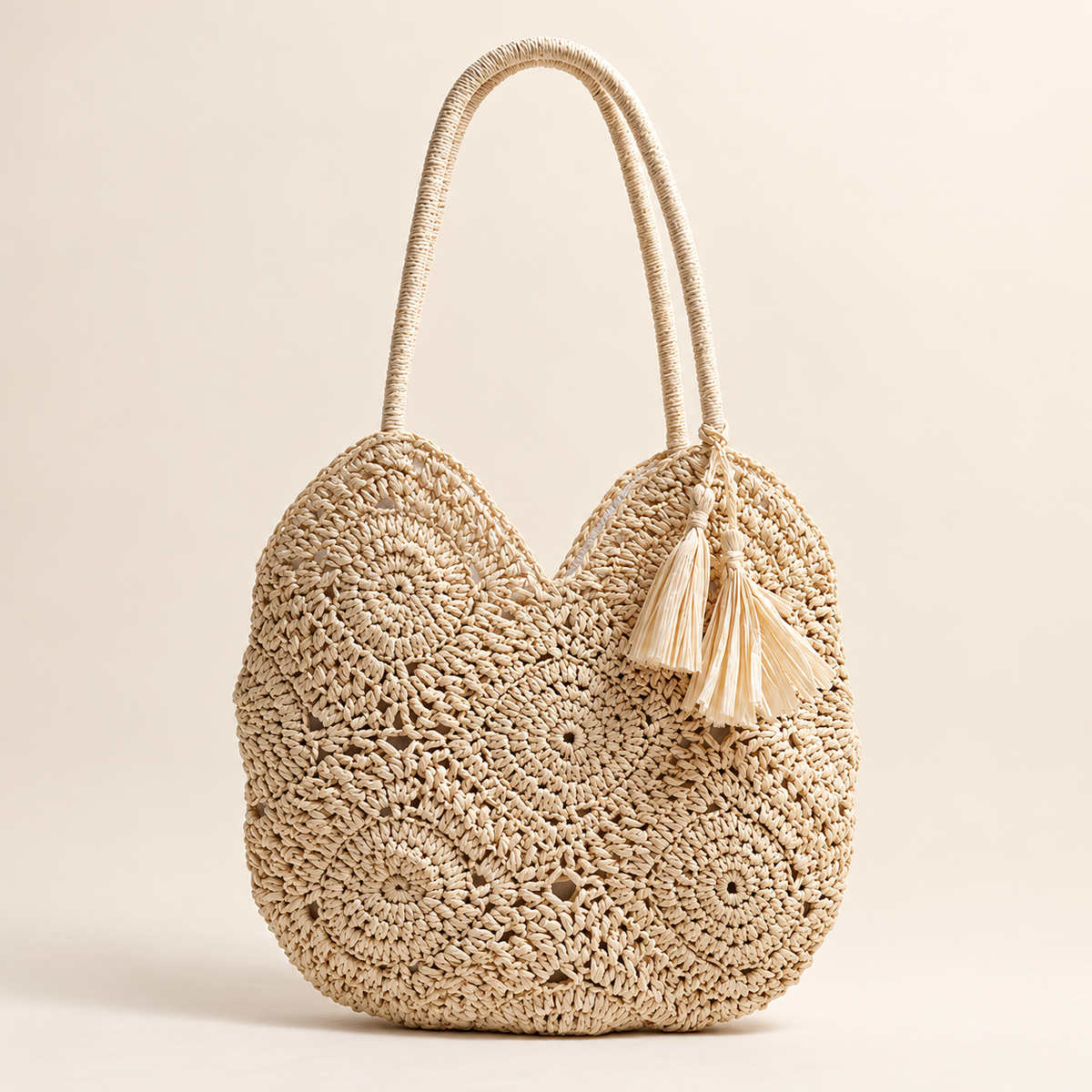 Hollow Weave Tassel Bag in cream, front view with rosette crochet motifs and a side tassel