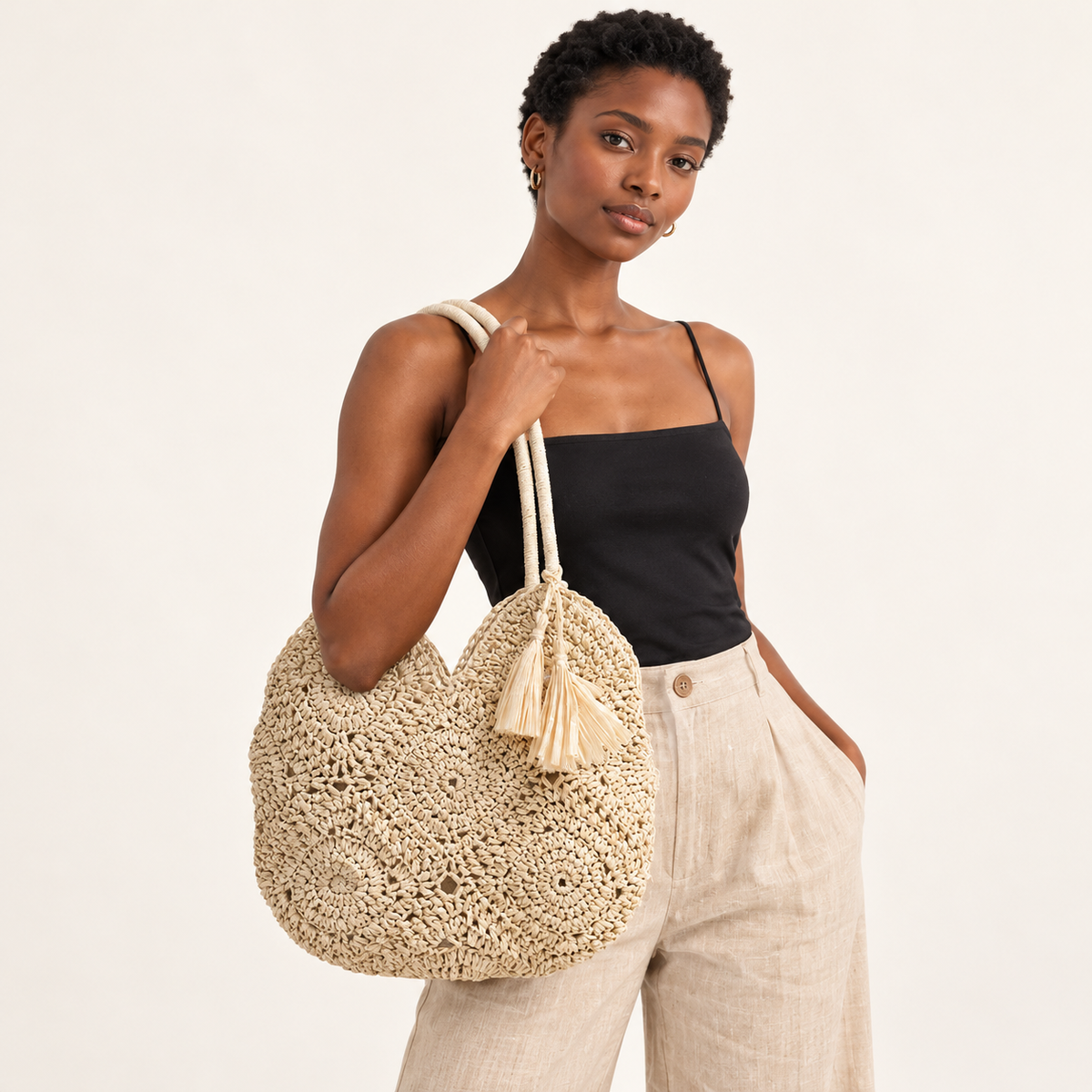 Woman carrying the Hollow Weave Tassel Bag with rosette crochet motifs and a side tassel