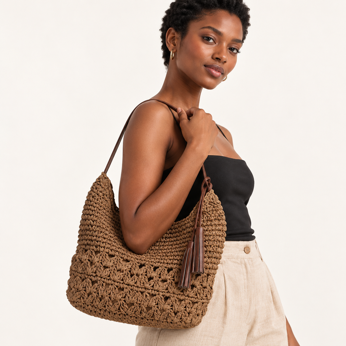 Woman carrying the Heart Tassel Shoulder Bag with heart-pattern openwork and a side tassel