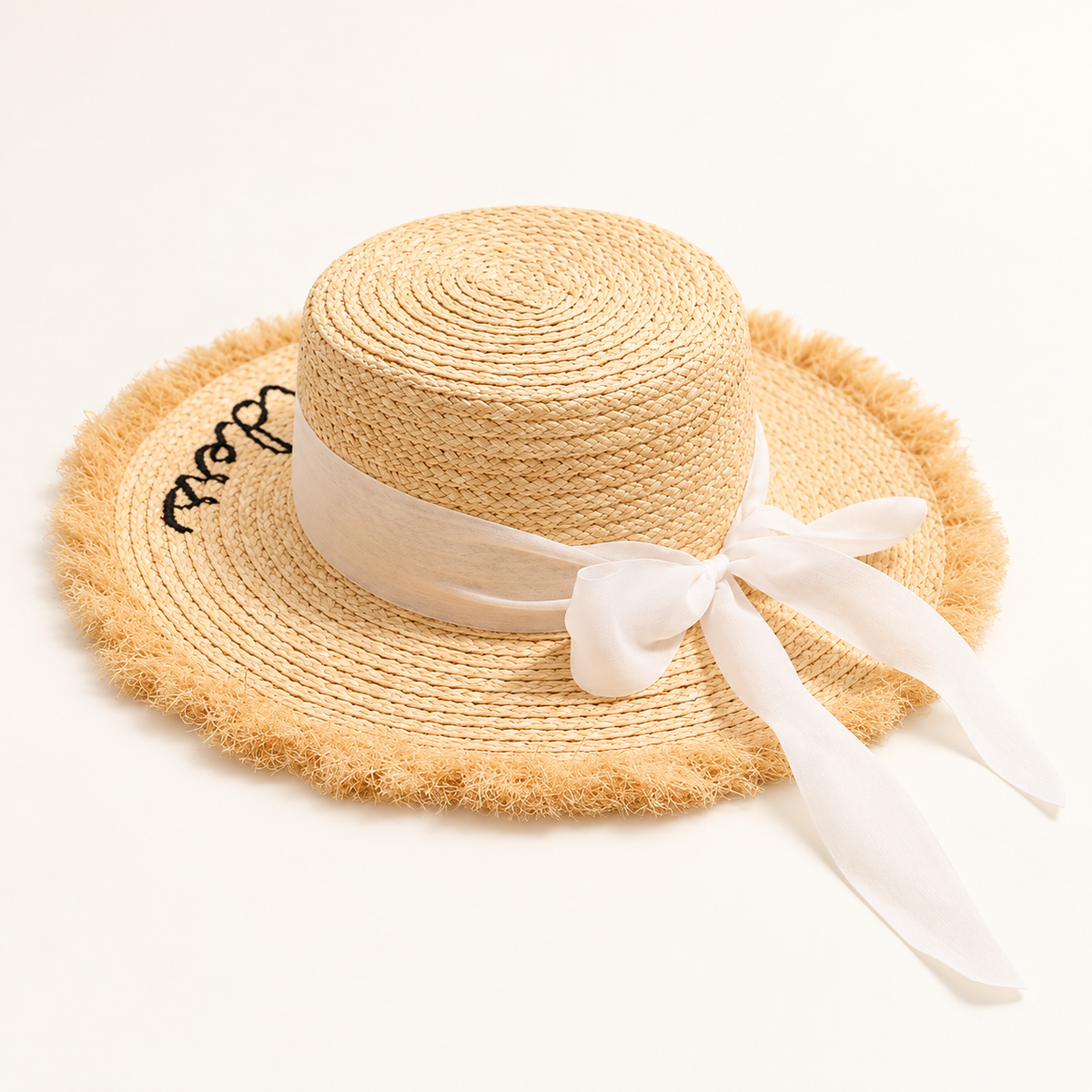 Ribbon Straw Sun Hat in natural straw, front view with an ivory bow and frayed brim