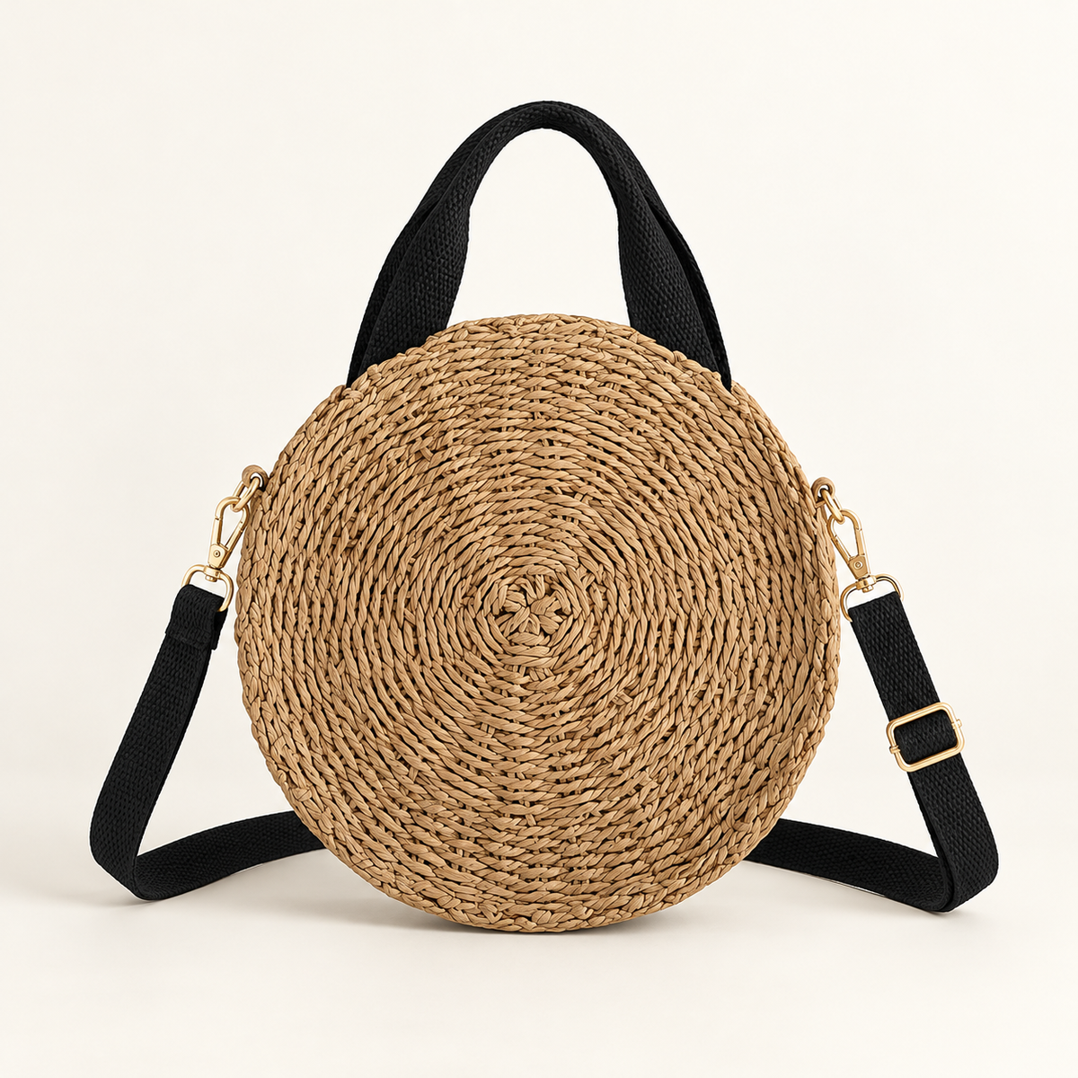 Round Woven Crossbody in natural tan, front view with a round coiled body and black straps