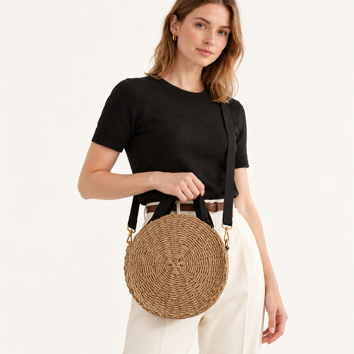 Woman carrying the Round Woven Crossbody with a round coiled body and black straps