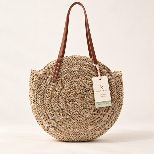 Round Woven Shoulder Bag in natural straw with a Solace & Straw hangtag