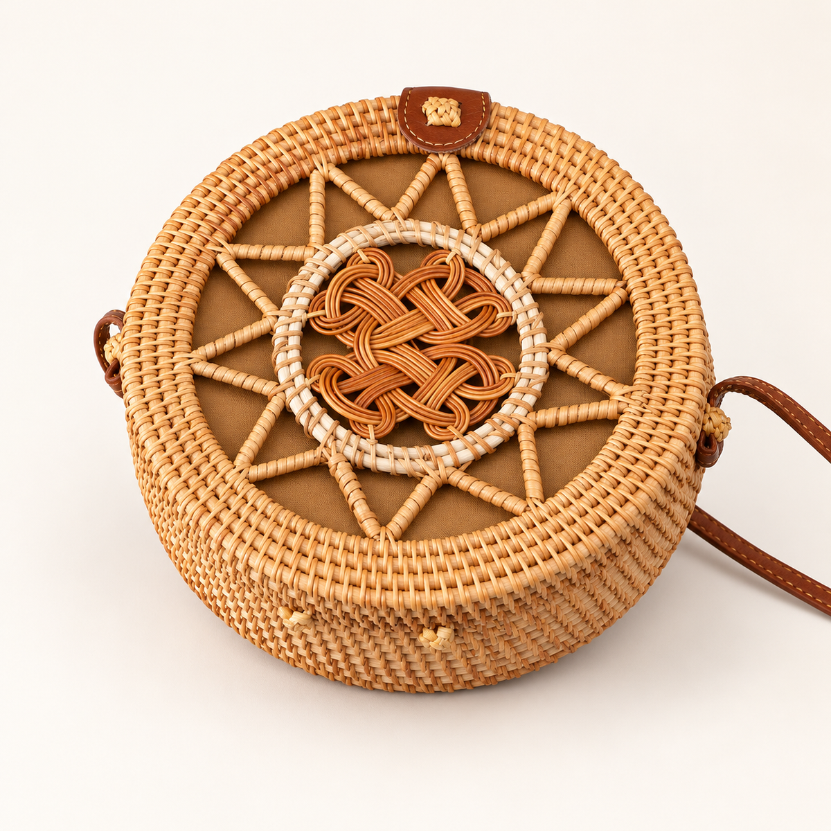 Round Rattan Crossbody, angled view showing a central woven knot and brown shoulder strap