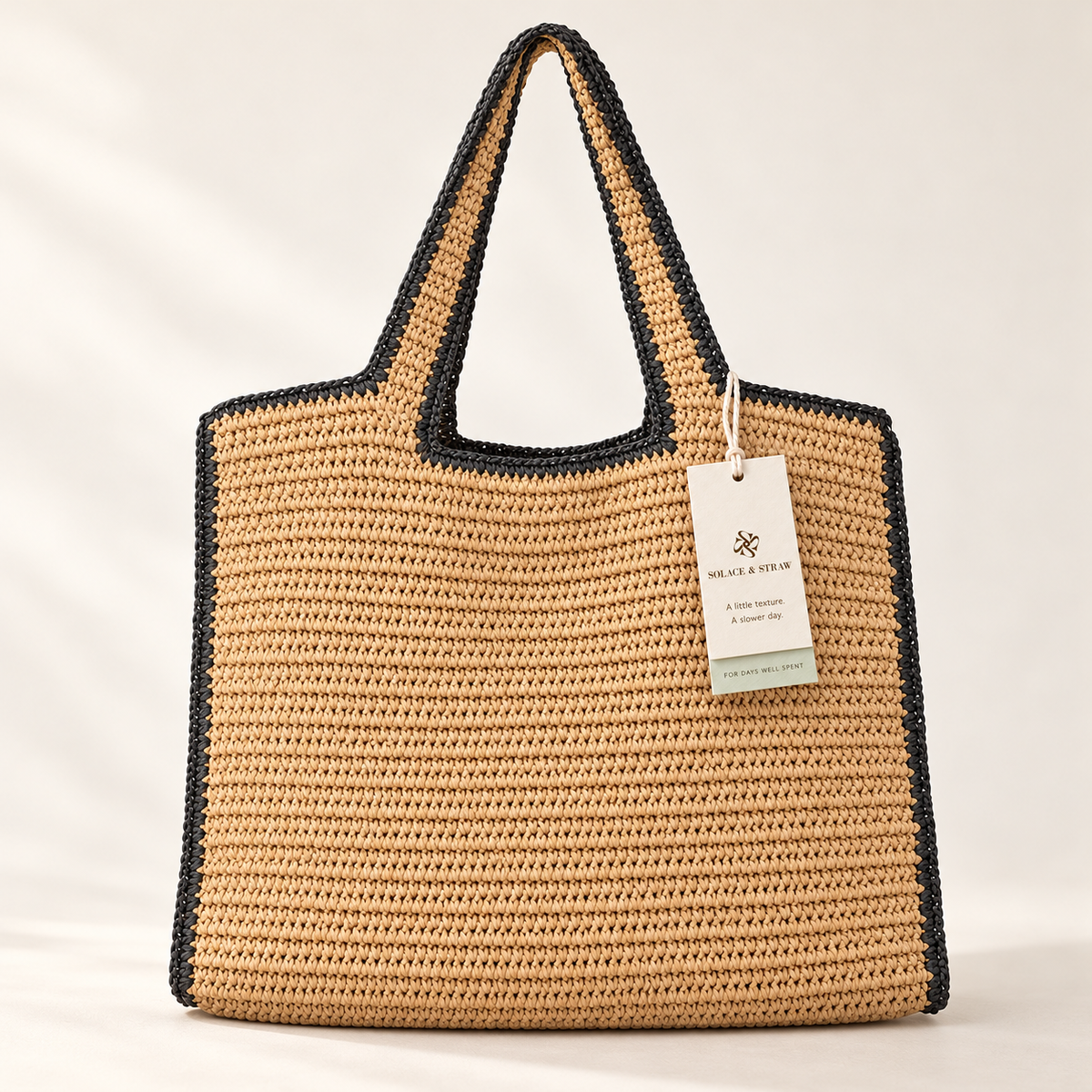 Contrast Edge Paper Woven Tote in tan / black trim, front view with Solace & Straw hangtag
