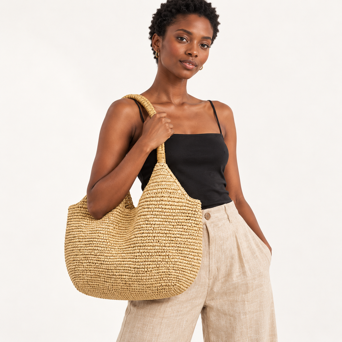 Woman carrying the Everyday Paper Woven Shopper in light brown, studio styling