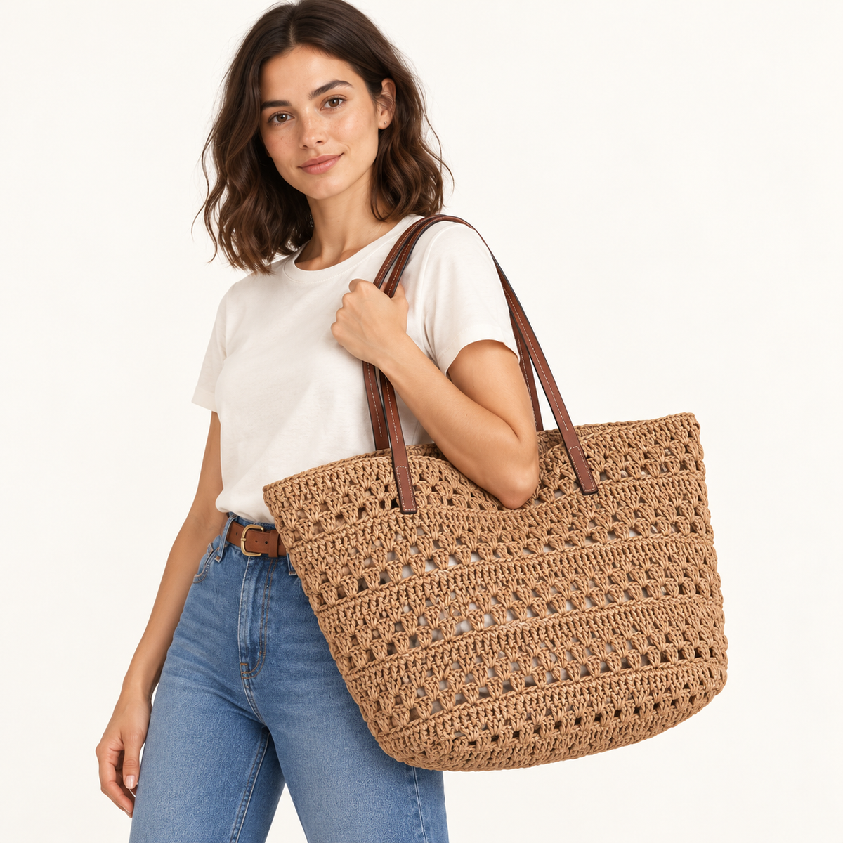 Woman carrying the Openwork Travel Woven Tote in brown / large, studio styling