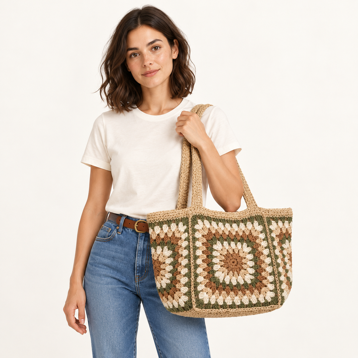 Woman carrying the Garden Square Paper Woven Tote in green / cream / tan, studio styling