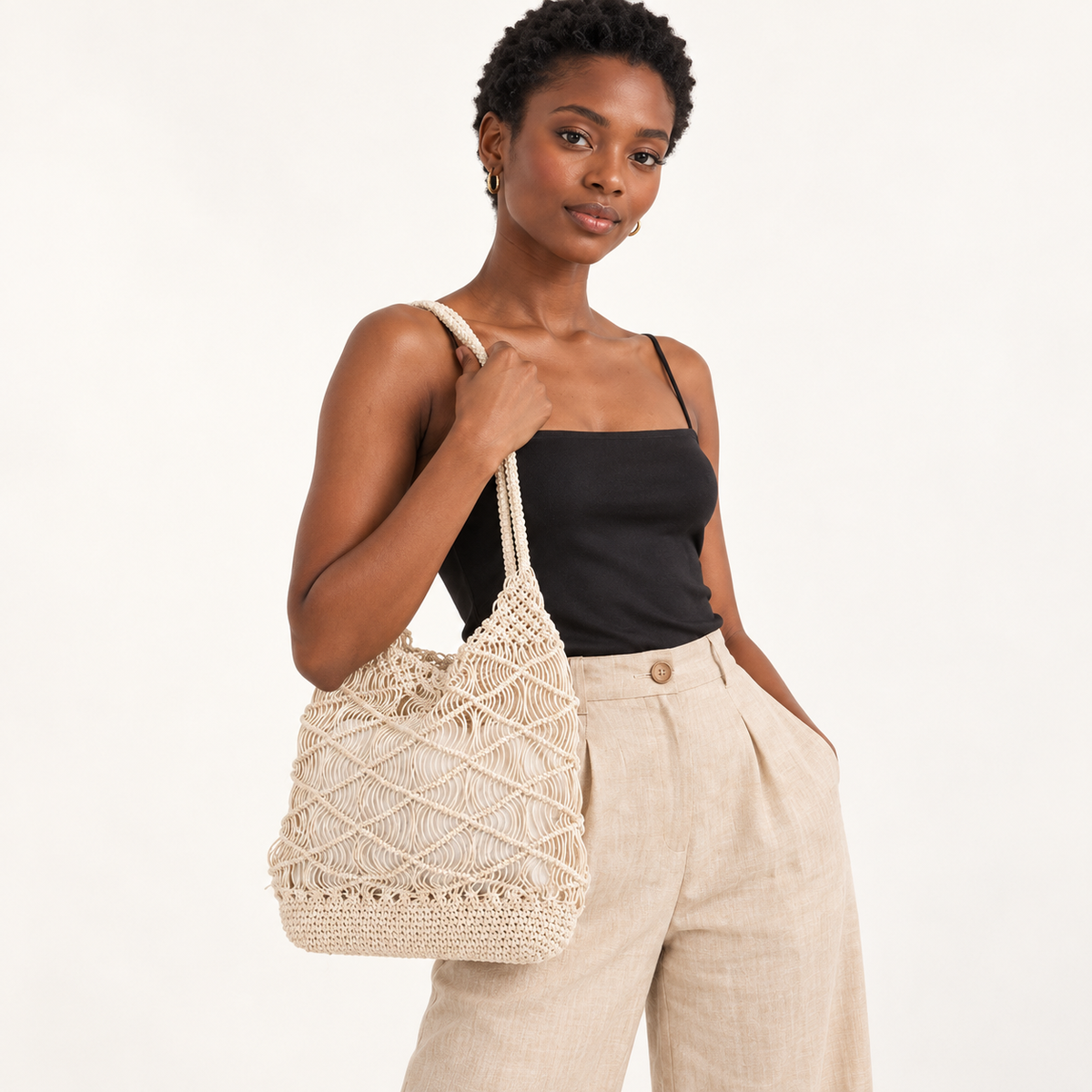 Woman carrying the Loop Stitch Drawstring Shoulder Bag in ivory / with inner bag, studio styling