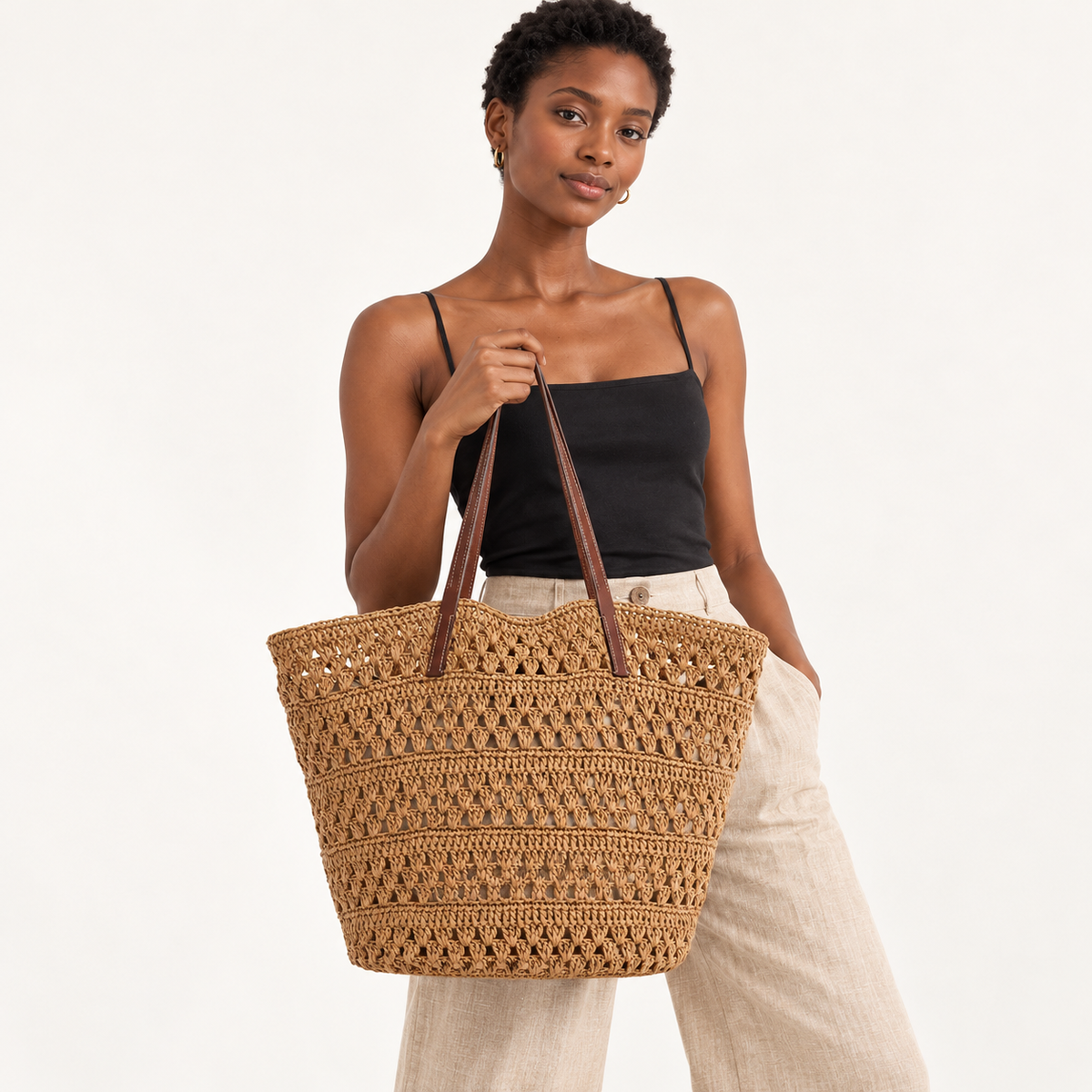 Woman carrying the Fan Stitch Paper Woven Tote in brown, studio styling