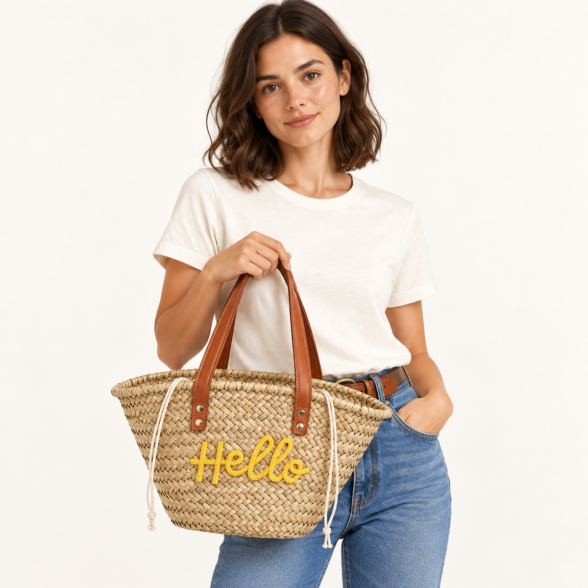 Woman carrying the Hello Embroidered Basket Tote in natural / yellow embroidery, studio styling
