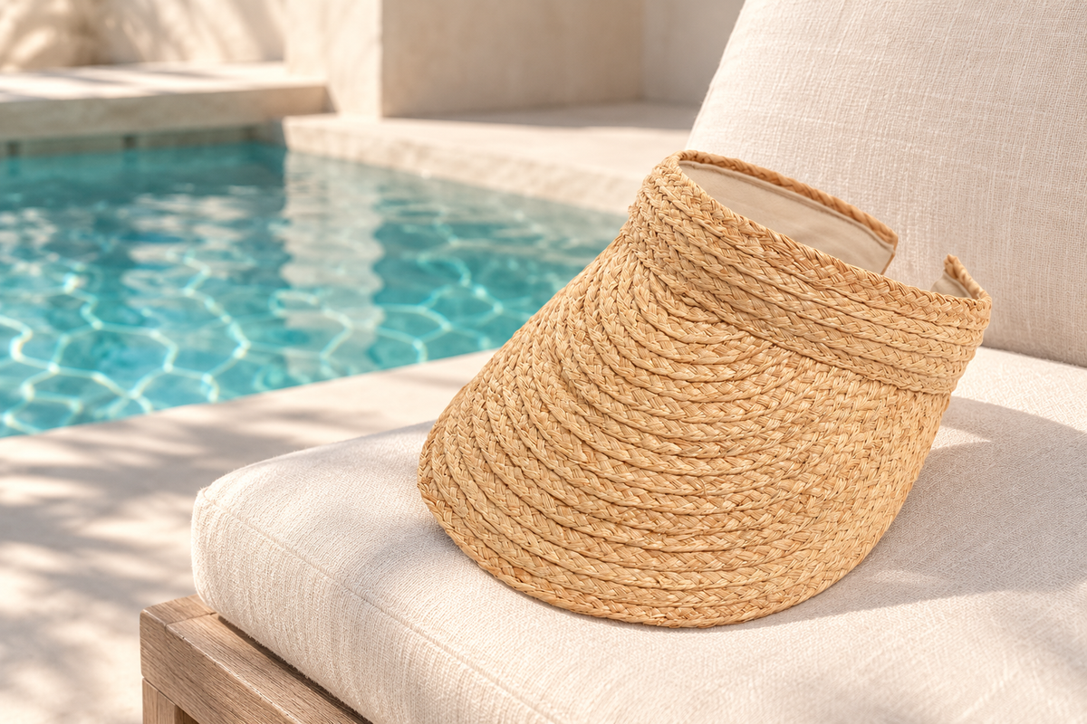 Natural Open Top Straw Visor on a linen chair beside a turquoise pool
