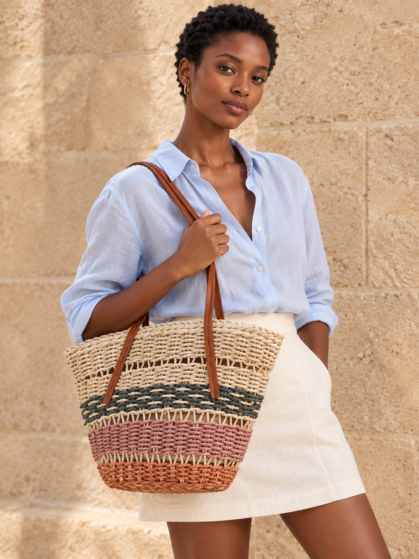Woman holding the Color Block Basket Tote against a pale blue shirt and ivory skirt