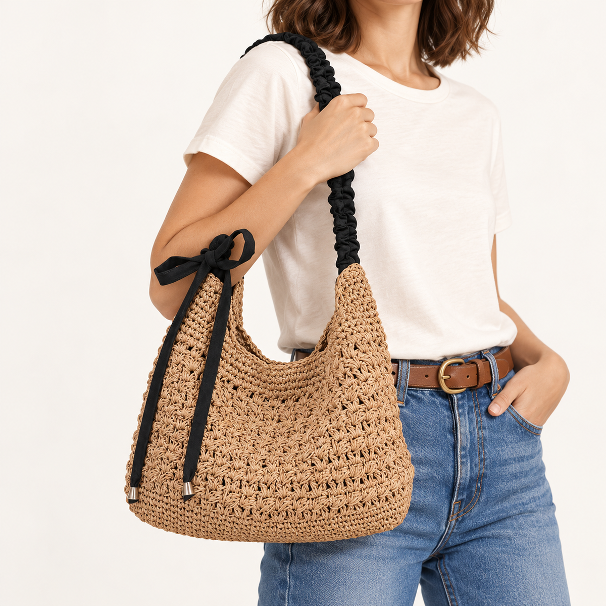 Woman carrying the Bow Detail Woven Shoulder Bag in natural / black bow