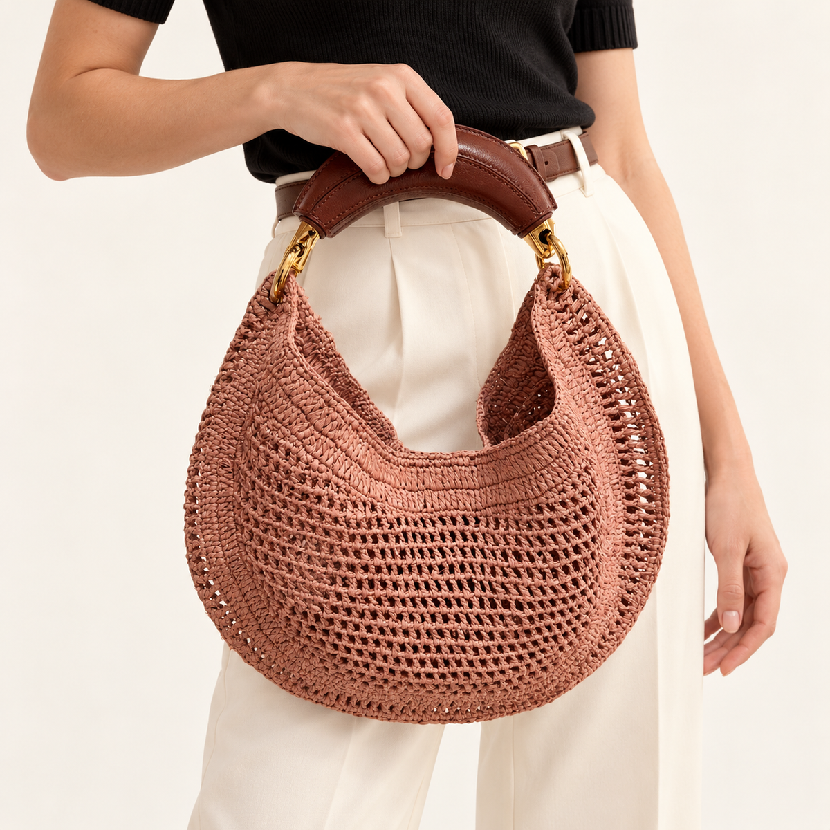 Woman carrying the Crescent Woven Top Handle Bag in rose